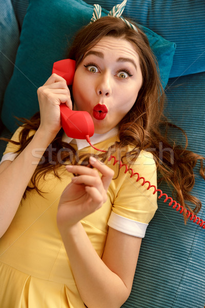 Top view of shocked woman talking at handset Stock photo © deandrobot