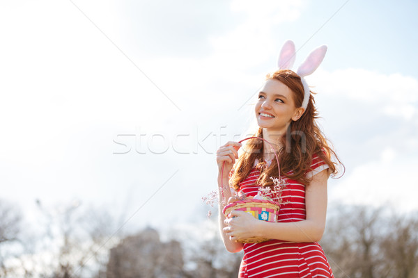 Woman with long red hair holding basket with painted eggs Stock photo © deandrobot