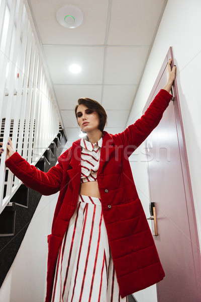 Mujer rojo abrigo pie pasillo atractivo Foto stock © deandrobot