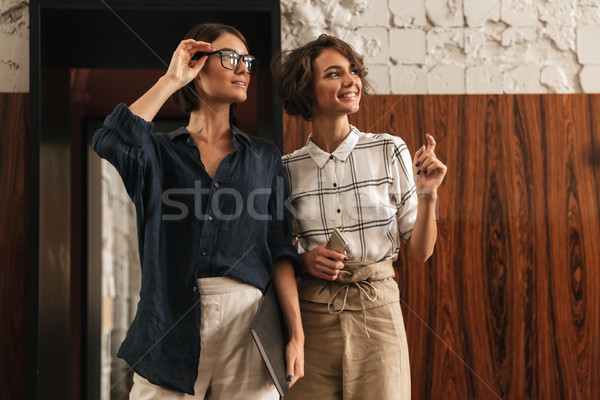 Two Pretty Smiling friends in co working office Stock photo © deandrobot