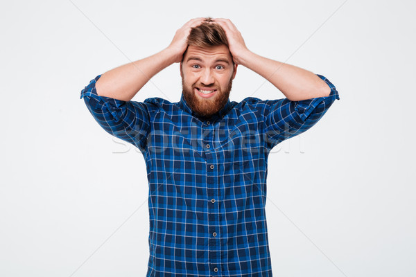 Stock photo: Confused man holding his head and looking camera isolated