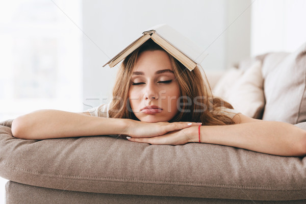 Young woman sleep on sofa with book on head Stock photo © deandrobot