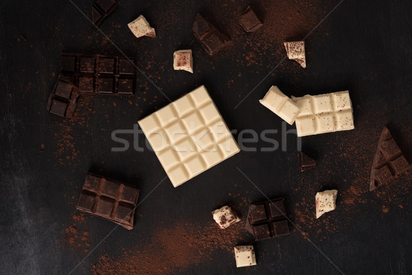 Top view of white and dark crashed chocolate bar tiles Stock photo © deandrobot