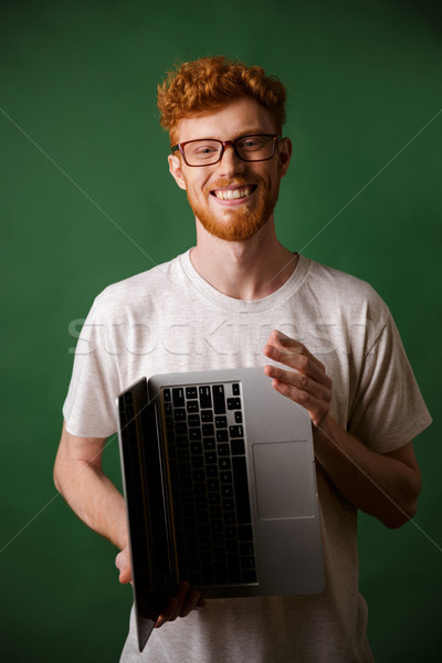 Cheerful readhead bearded man in glasses and white tshirt holdin Stock photo © deandrobot