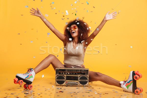 Charming young african woman in retro wear and roller scates thr Stock photo © deandrobot