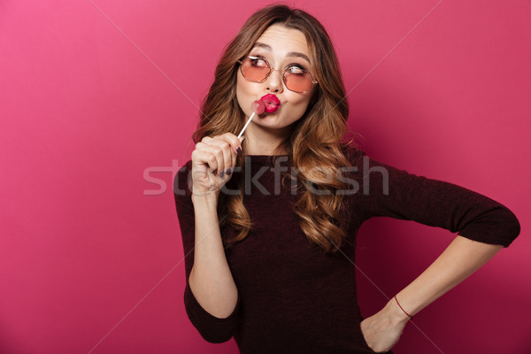 Beautiful lady wearing glasses eating candy. Stock photo © deandrobot