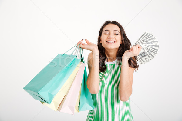 Portrait of a happy girl in dress holding shopping bags Stock photo © deandrobot