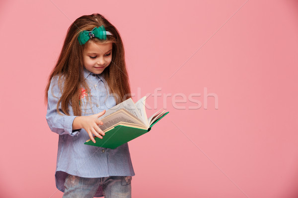 Image of smart schoolgirl 5-6 years with long auburn hair readin Stock photo © deandrobot