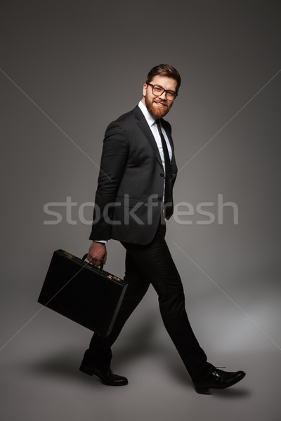 Full length portrait of a smiling young businessman Stock photo © deandrobot