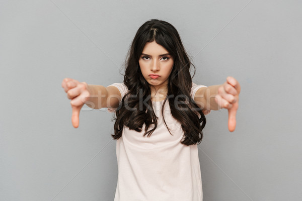 Elégedetlen fiatal hölgy áll izolált mutat Stock fotó © deandrobot