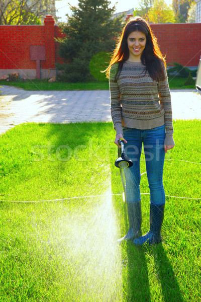 Full-length portrait of a woman is watering a garden Stock photo © deandrobot