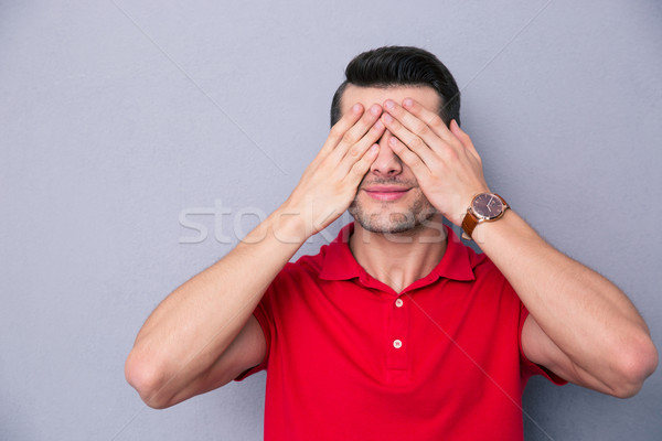 Casual man covering his eyes with fingers Stock photo © deandrobot