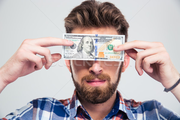 Man covering his eyes with bill of USA dollar  Stock photo © deandrobot