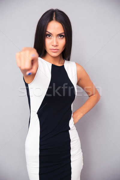Serious woman pointing finger at camera Stock photo © deandrobot