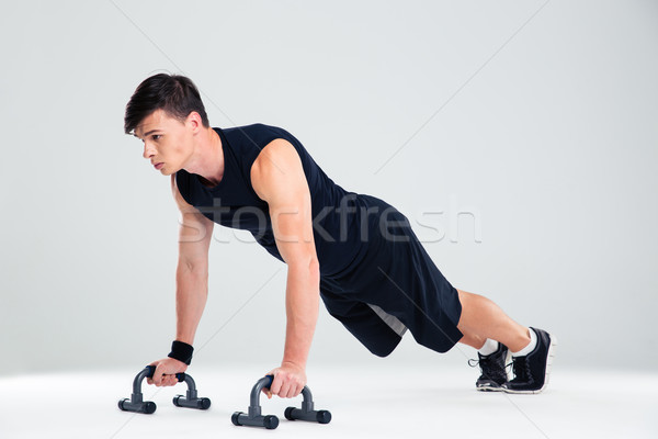Portret fitness człowiek pompek odizolowany biały Zdjęcia stock © deandrobot