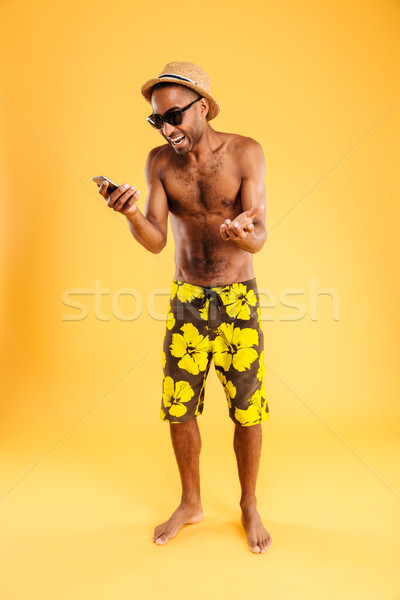 Portrait of afro american man screaming on smartphone Stock photo © deandrobot