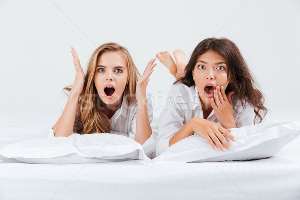 Kobiet bed poduszki patrząc kamery dwa Zdjęcia stock © deandrobot