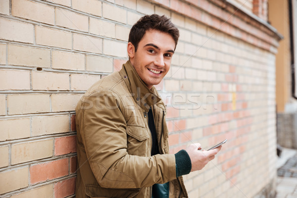 Stockfoto: Glimlachend · jonge · man · telefoon · buitenshuis · foto