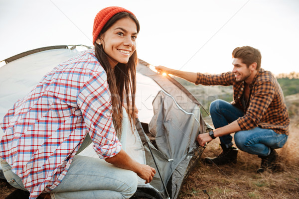 Young happy couple setting up a tent outdoors Stock photo © deandrobot