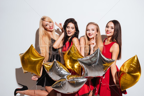 Portrait of four cheerful young women with star shaped balloons Stock photo © deandrobot