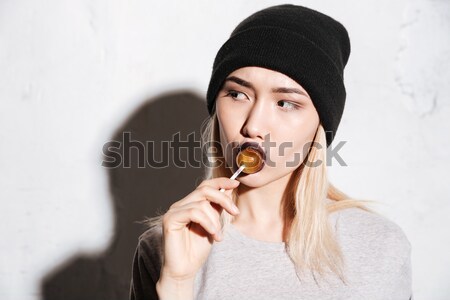 Stock photo: Woman with black lips in hat showing silence sign