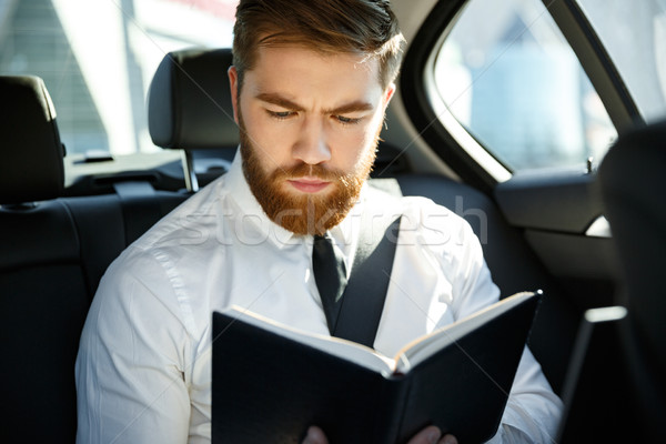Poważny człowiek biznesu czytania książki brodaty posiedzenia Zdjęcia stock © deandrobot