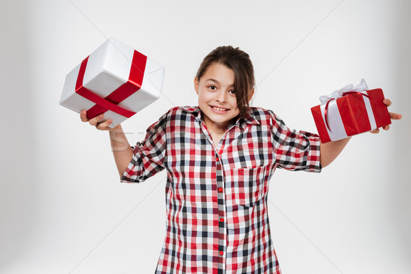 Cheerful young girl posing with two gifts Stock photo © deandrobot