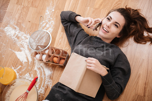 Young smiling girl talking on mobile phone and cooking Stock photo © deandrobot