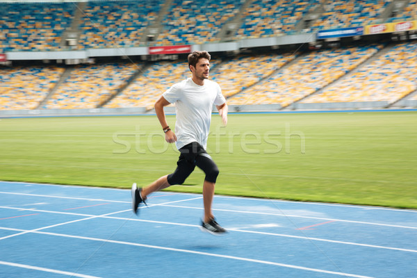 Side view of a young professional sprinter running Stock photo © deandrobot