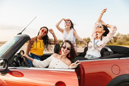 Happy emotional four young women friends sitting in car Stock photo © deandrobot