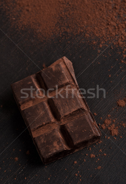 Dark chocolate bar covered with chocolate powder Stock photo © deandrobot