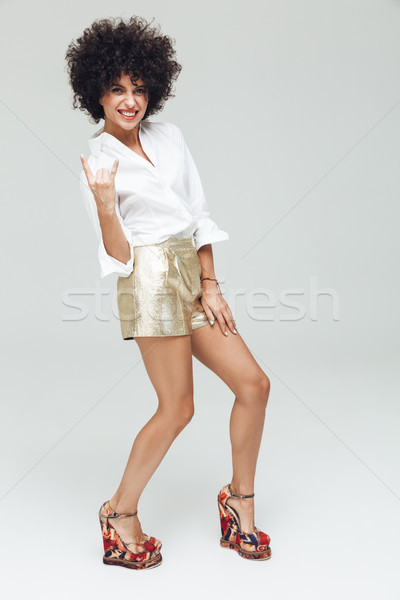 Emotional retro woman showing rock gesture. Stock photo © deandrobot