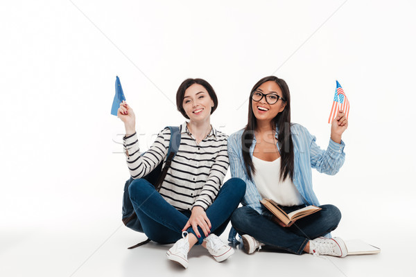 Two young smiling female students holding us flags Stock photo © deandrobot