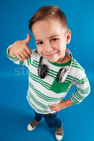 Vertical top view image of young boy posing with headphone Stock photo © deandrobot