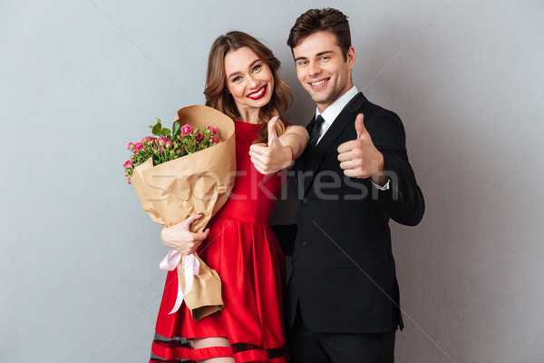 Portrait of a joyful happy couple holding flower bouquet Stock photo © deandrobot