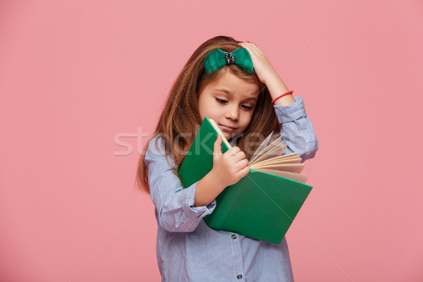 Image of amusing girl 5-6 years in shirt grabbing her head while Stock photo © deandrobot