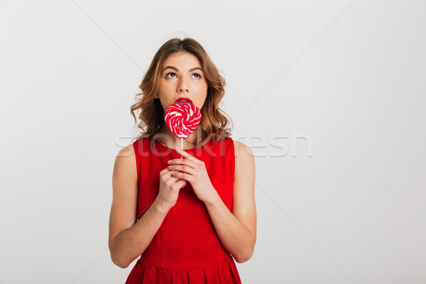 Portrait of a pretty young woman dressed in red dress Stock photo © deandrobot