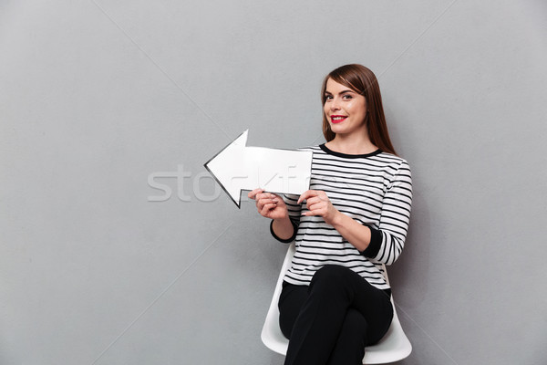 Portrait of a smiling woman sitting on chair Stock photo © deandrobot