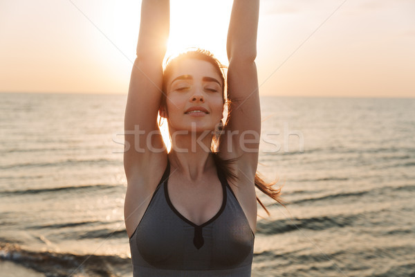 Attractive young sportswoman doing stretching exercises Stock photo © deandrobot
