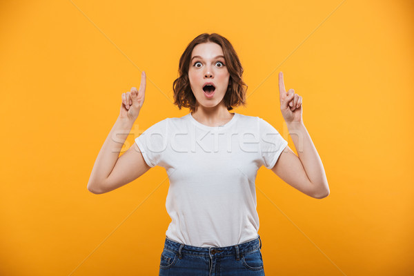 Excited emotional young woman showing copyspace. Stock photo © deandrobot