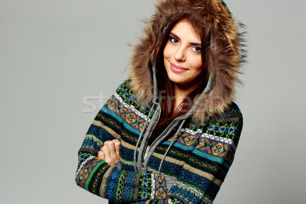 Young happy smiling woman in warm winter outfit on gray background Stock photo © deandrobot