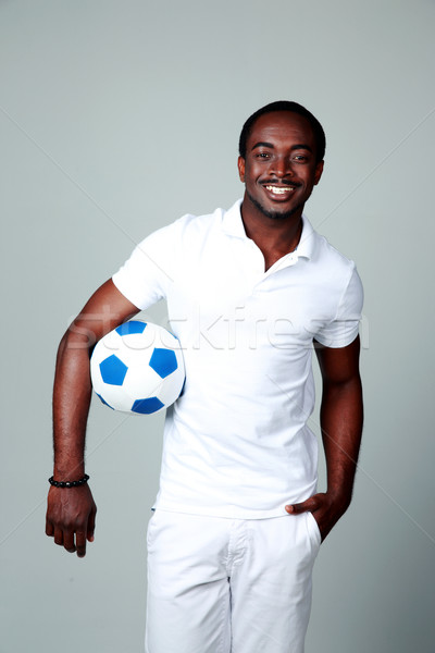Lächelnd african Mann halten Fußball grau Stock foto © deandrobot