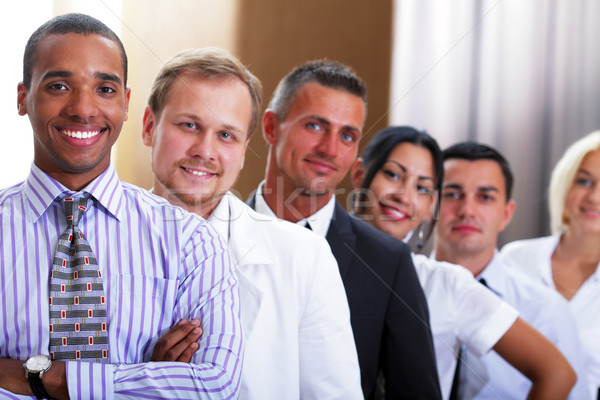 group of business people smiling in an office lined up Stock photo © deandrobot