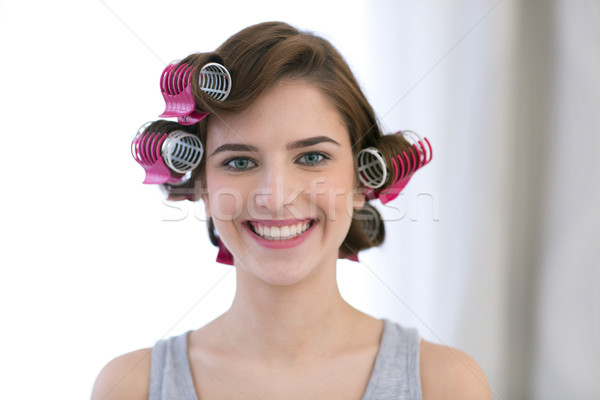 Portrait of a smiling woman with curlers on her head Stock photo © deandrobot