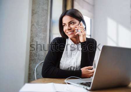 Cheerful businesswoman using laptop in cafe Stock photo © deandrobot
