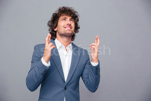 Portrait of a businessman praying with crossed fingers  Stock photo © deandrobot