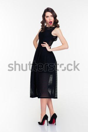 Wondered curly female with makeup in retro style looking back  Stock photo © deandrobot