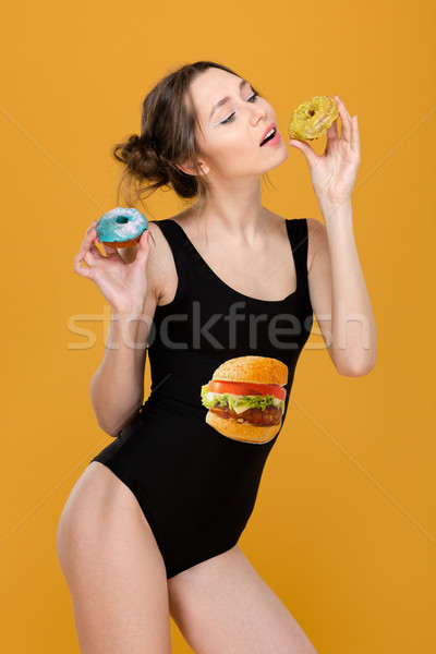 Playful attractive woman in black designer swimsuit posing with donuts  Stock photo © deandrobot