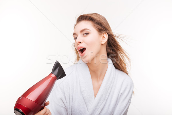 Playful cute woman singing and drying her hair with dryer Stock photo © deandrobot