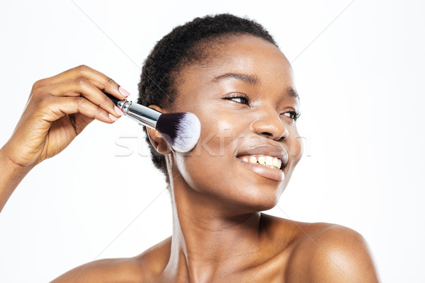 Afro american woman applying makeup with brush Stock photo © deandrobot